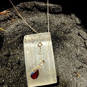 Sterling silver necklace with garnet charm.